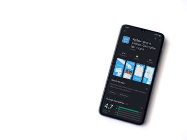 Lod, Israel - 8 Temmuz 2020: PayBox uygulaması oyun mağazası sayfası beyaz arkaplanda izole edilmiş siyah bir cep telefonu ekranında. Üst görünüm düzlüğü kopyalama alanı ile yatıyordu.