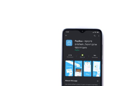 Lod, Israel - 8 Temmuz 2020: PayBox uygulaması oyun mağazası sayfası beyaz arkaplanda izole edilmiş siyah bir cep telefonu ekranında. Üst görünüm düzlüğü kopyalama alanı ile yatıyordu.