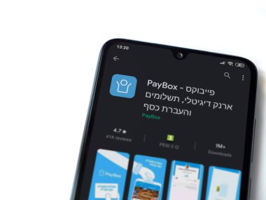Lod, Israel - 8 Temmuz 2020: PayBox uygulaması oyun mağazası sayfası beyaz arkaplanda izole edilmiş siyah bir cep telefonu ekranında. Üst görünüm düzlüğü kopyalama alanı ile yatıyordu.