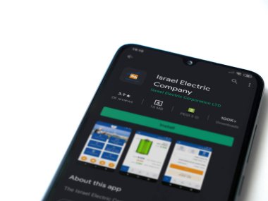 Lod, Israil - 8 Temmuz 2020: Israel Electric Corporation uygulama oyun mağazası sayfası beyaz arkaplanda izole edilmiş siyah bir cep telefonu ekranında. Üst görünüm düzlüğü kopyalama alanı ile yatıyordu.