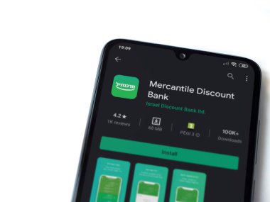 Lod, Israel - 8 Temmuz 2020: Bank Mercantil Discount uygulaması oyun mağazası sayfası beyaz arkaplanda izole edilmiş siyah bir cep telefonu ekranında. Üst görünüm düzlüğü kopyalama alanı ile yatıyordu.