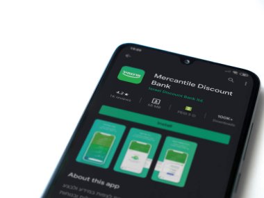 Lod, Israel - 8 Temmuz 2020: Bank Mercantil Discount uygulaması oyun mağazası sayfası beyaz arkaplanda izole edilmiş siyah bir cep telefonu ekranında. Üst görünüm düzlüğü kopyalama alanı ile yatıyordu.