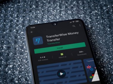 Lod, Israel - 8 Temmuz 2020: Metalik arka planda siyah bir cep telefonunun ekranında TransferWise uygulaması oyun mağazası sayfası. Üst görünüm yatağını kapat.