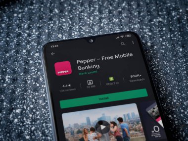 Lod, Israel - 8 Temmuz 2020: Metalik arka planda siyah bir cep telefonunun sergilendiği biber uygulaması oyun mağazası sayfası. Üst görünüm yatağını kapat.