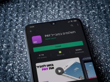 Lod, Israel - 8 Temmuz 2020: Metalik bir arka planda siyah bir cep telefonunun ekranında paralı uygulama oyun mağazası sayfası. Üst görünüm yatağını kapat.