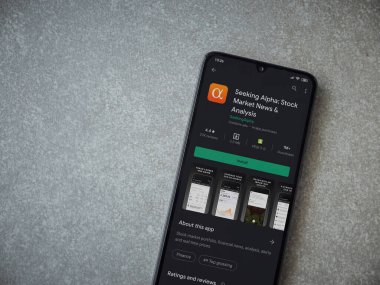 Lod, Israel - 8 Temmuz 2020: Seramik taş zemin üzerinde siyah bir cep telefonu ekranında Alfa uygulaması oyun mağazası sayfası aranıyor. Üst görünüm düzlüğü kopyalama alanı ile yatıyordu.