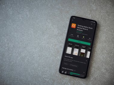 Lod, Israel - 8 Temmuz 2020: Seramik taş zemin üzerinde siyah bir cep telefonu ekranında Alfa uygulaması oyun mağazası sayfası aranıyor. Üst görünüm düzlüğü kopyalama alanı ile yatıyordu.