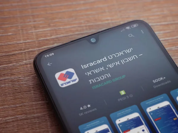 Lod, Israel - 8 Temmuz 2020: Isracard uygulama oyun mağazası sayfası ahşap arka planda siyah bir cep telefonu ekranında. Üst görünüm düzlüğü kopyalama alanı ile yatıyordu.