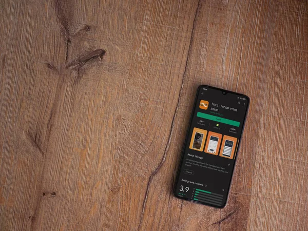 Lod, Israel - 8 Temmuz 2020: Bank Mizrahi Tefahot uygulaması oyun mağazası sayfası ahşap arka planda siyah bir cep telefonu sergilenmektedir. Üst görünüm düzlüğü kopyalama alanı ile yatıyordu.