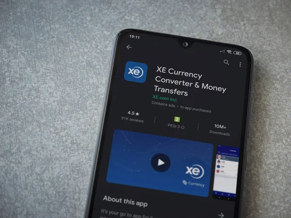 Lod, Israel - 8 Temmuz 2020: XE Para Birimi uygulaması oyun mağazası sayfası seramik taş zemin üzerinde siyah bir cep telefonu görüntüsü. Üst görünüm düzlüğü kopyalama alanı ile yatıyordu.