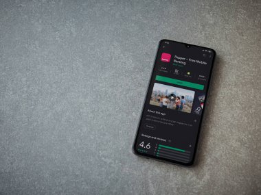 Lod, Israel - 8 Temmuz 2020: Biber uygulaması oyun mağazası sayfası seramik taş zemin üzerinde siyah bir cep telefonu görüntüsü. Üst görünüm düzlüğü kopyalama alanı ile yatıyordu.