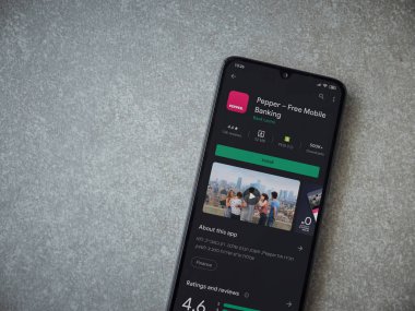 Lod, Israel - 8 Temmuz 2020: Biber uygulaması oyun mağazası sayfası seramik taş zemin üzerinde siyah bir cep telefonu görüntüsü. Üst görünüm düzlüğü kopyalama alanı ile yatıyordu.