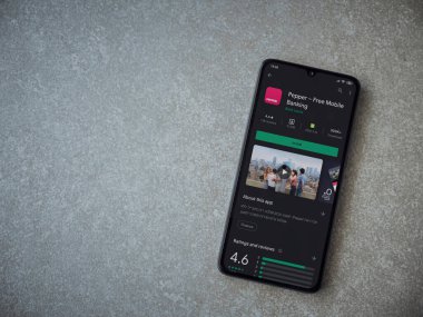 Lod, Israel - 8 Temmuz 2020: Biber uygulaması oyun mağazası sayfası seramik taş zemin üzerinde siyah bir cep telefonu görüntüsü. Üst görünüm düzlüğü kopyalama alanı ile yatıyordu.