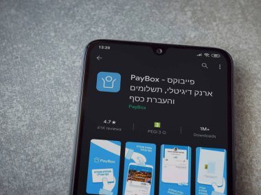 Lod, Israel - 8 Temmuz 2020: PayBox uygulaması oyun mağazası sayfası seramik taş zemin üzerinde siyah bir cep telefonu görüntüsü. Üst görünüm düzlüğü kopyalama alanı ile yatıyordu.