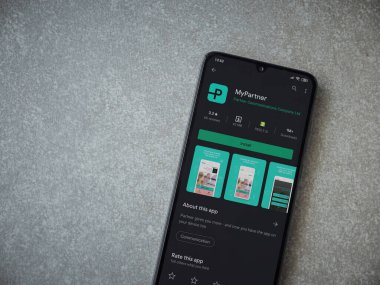 Lod, Israel - 8 Temmuz 2020: Partner Uygulama Oyun Mağazası sayfam seramik taştan arka planda siyah bir cep telefonu ekranında. Üst görünüm düzlüğü kopyalama alanı ile yatıyordu.