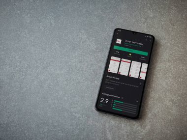 Lod, Israel - 8 Temmuz 2020: Israel Postal uygulama oyun mağazası sayfası seramik taş zemin üzerinde siyah bir cep telefonu sergilenmektedir. Üst görünüm düzlüğü kopyalama alanı ile yatıyordu.