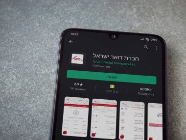 Lod, Israel - 8 Temmuz 2020: Israel Postal uygulama oyun mağazası sayfası seramik taş zemin üzerinde siyah bir cep telefonu sergilenmektedir. Üst görünüm düzlüğü kopyalama alanı ile yatıyordu.