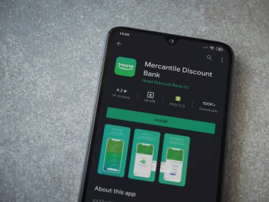 Lod, Israel - 8 Temmuz 2020: Bank Mercantil Discount uygulaması oyun mağazası sayfası seramik taş zemin üzerinde siyah bir cep telefonu görüntüsü. Üst görünüm düzlüğü kopyalama alanı ile yatıyordu.