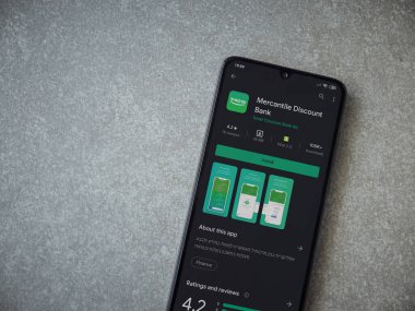 Lod, Israel - 8 Temmuz 2020: Bank Mercantil Discount uygulaması oyun mağazası sayfası seramik taş zemin üzerinde siyah bir cep telefonu görüntüsü. Üst görünüm düzlüğü kopyalama alanı ile yatıyordu.