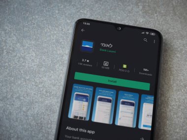 Lod, Israel - 8 Temmuz 2020: Bank Leumi uygulama oyun mağazası sayfası seramik taş zemin üzerinde siyah bir cep telefonu görüntüsü. Üst görünüm düzlüğü kopyalama alanı ile yatıyordu.