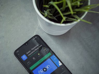 Lod, Israel - 8 Temmuz 2020: Mermer arka planda Robin uygulaması oyun mağazası sayfası olan siyah cep telefonlu modern minimalist ofis çalışma alanı. Üst görünüm yatağını kapat.