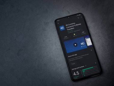Lod, Israel - 8 Temmuz 2020: XE Para Birimi uygulaması oyun mağazası sayfası koyu mermer taştan arka planda siyah bir cep telefonu görüntüsü. Üst görünüm düzlüğü kopyalama alanı ile yatıyordu.