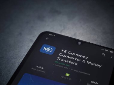 Lod, Israel - 8 Temmuz 2020: XE Para Birimi uygulaması oyun mağazası sayfası koyu mermer taştan arka planda siyah bir cep telefonu görüntüsü. Üst görünüm düzlüğü kopyalama alanı ile yatıyordu.