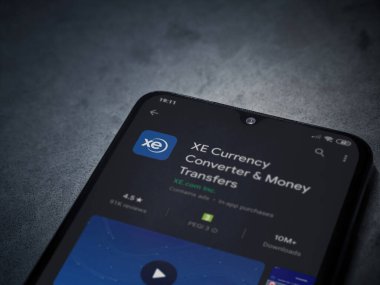 Lod, Israel - 8 Temmuz 2020: XE Para Birimi uygulaması oyun mağazası sayfası koyu mermer taştan arka planda siyah bir cep telefonu görüntüsü. Üst görünüm düzlüğü kopyalama alanı ile yatıyordu.