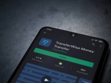 Lod, Israel - 8 Temmuz 2020: TransferWise uygulama oyun mağazası sayfası koyu mermer taşlı arka planda siyah bir cep telefonunun ekranında. Üst görünüm düzlüğü kopyalama alanı ile yatıyordu.