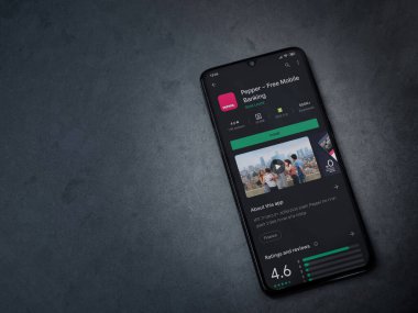 Lod, Israel - 8 Temmuz 2020: Koyu mermer taştan arka planda siyah bir cep telefonunun sergilendiği biber uygulaması oyun mağazası sayfası. Üst görünüm düzlüğü kopyalama alanı ile yatıyordu.