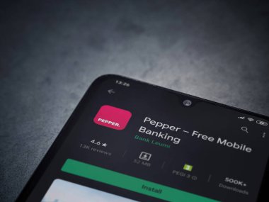 Lod, Israel - 8 Temmuz 2020: Koyu mermer taştan arka planda siyah bir cep telefonunun sergilendiği biber uygulaması oyun mağazası sayfası. Üst görünüm düzlüğü kopyalama alanı ile yatıyordu.