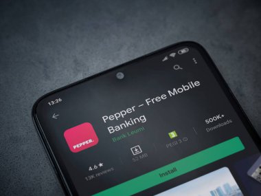 Lod, Israel - 8 Temmuz 2020: Koyu mermer taştan arka planda siyah bir cep telefonunun sergilendiği biber uygulaması oyun mağazası sayfası. Üst görünüm düzlüğü kopyalama alanı ile yatıyordu.