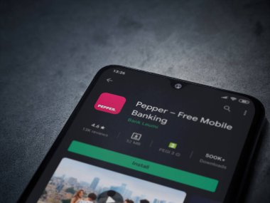 Lod, Israel - 8 Temmuz 2020: Koyu mermer taştan arka planda siyah bir cep telefonunun sergilendiği biber uygulaması oyun mağazası sayfası. Üst görünüm düzlüğü kopyalama alanı ile yatıyordu.