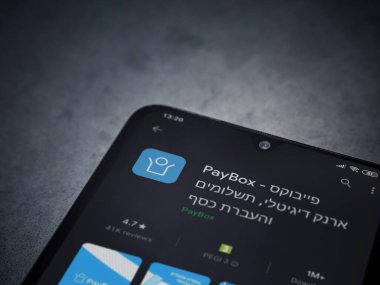 Lod, Israel - 8 Temmuz 2020: PayBox uygulaması oyun mağazası sayfası koyu mermer taştan arka planda siyah bir cep telefonunun ekranında. Üst görünüm düzlüğü kopyalama alanı ile yatıyordu.