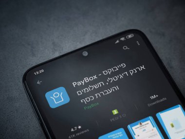 Lod, Israel - 8 Temmuz 2020: PayBox uygulaması oyun mağazası sayfası koyu mermer taştan arka planda siyah bir cep telefonunun ekranında. Üst görünüm düzlüğü kopyalama alanı ile yatıyordu.