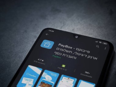 Lod, Israel - 8 Temmuz 2020: PayBox uygulaması oyun mağazası sayfası koyu mermer taştan arka planda siyah bir cep telefonunun ekranında. Üst görünüm düzlüğü kopyalama alanı ile yatıyordu.