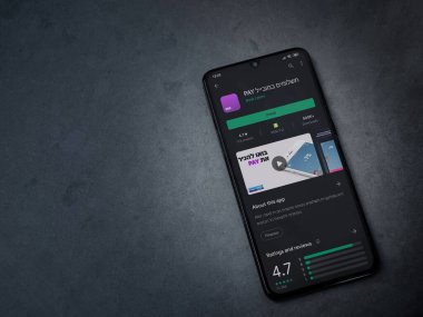 Lod, Israel - 8 Temmuz 2020: Koyu mermer taştan arka planda siyah bir cep telefonunun ekranında paralı uygulama oyun mağazası sayfası. Üst görünüm düzlüğü kopyalama alanı ile yatıyordu.