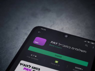 Lod, Israel - 8 Temmuz 2020: Koyu mermer taştan arka planda siyah bir cep telefonunun ekranında paralı uygulama oyun mağazası sayfası. Üst görünüm düzlüğü kopyalama alanı ile yatıyordu.