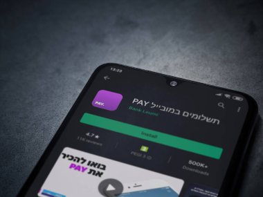 Lod, Israel - 8 Temmuz 2020: Koyu mermer taştan arka planda siyah bir cep telefonunun ekranında paralı uygulama oyun mağazası sayfası. Üst görünüm düzlüğü kopyalama alanı ile yatıyordu.
