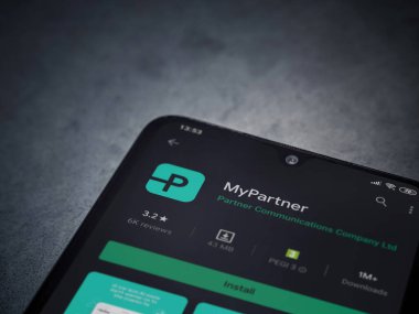 Lod, Israel - 8 Temmuz 2020: Partner Uygulama Oyun Mağazası sayfam koyu mermer taştan arka planda siyah bir cep telefonu ekranında. Üst görünüm düzlüğü kopyalama alanı ile yatıyordu.