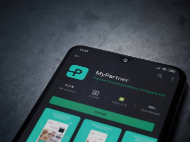 Lod, Israel - 8 Temmuz 2020: Partner Uygulama Oyun Mağazası sayfam koyu mermer taştan arka planda siyah bir cep telefonu ekranında. Üst görünüm düzlüğü kopyalama alanı ile yatıyordu.