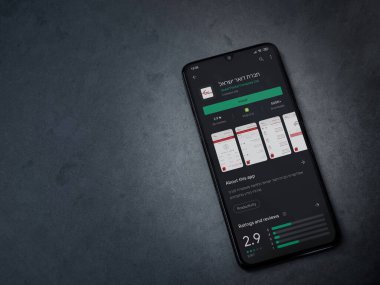Lod, Israel - 8 Temmuz 2020: İsrail Postası uygulama oyun mağazası sayfası koyu mermer taştan arka planda siyah bir cep telefonunun ekranında. Üst görünüm düzlüğü kopyalama alanı ile yatıyordu.