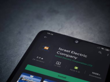 Lod, Israel - 8 Temmuz 2020: Israel Electric Corporation uygulama oyun mağazası sayfası koyu mermer taştan arka planda siyah bir cep telefonunun ekranında. Üst görünüm düzlüğü kopyalama alanı ile yatıyordu.