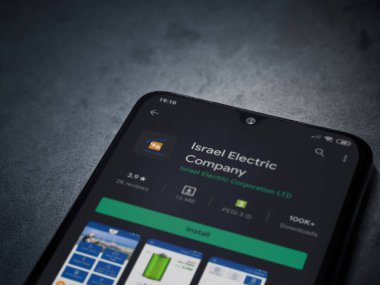 Lod, Israel - 8 Temmuz 2020: Israel Electric Corporation uygulama oyun mağazası sayfası koyu mermer taştan arka planda siyah bir cep telefonunun ekranında. Üst görünüm düzlüğü kopyalama alanı ile yatıyordu.