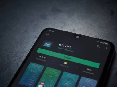 Lod, Israel - 8 Temmuz 2020: Bit uygulama oyun mağazası sayfası koyu mermer taşlı arka planda siyah bir cep telefonunun ekranında. Üst görünüm düzlüğü kopyalama alanı ile yatıyordu.