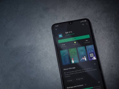 Lod, Israel - 8 Temmuz 2020: Bit uygulama oyun mağazası sayfası koyu mermer taşlı arka planda siyah bir cep telefonunun ekranında. Üst görünüm düzlüğü kopyalama alanı ile yatıyordu.