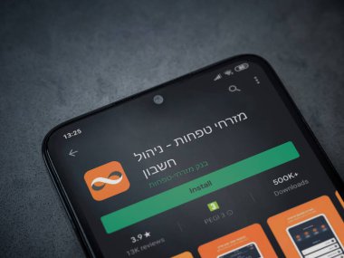 Lod, Israel - 8 Temmuz 2020: Bank Mizrahi Tefahot uygulaması oyun mağazası sayfası koyu mermer taştan arka planda siyah bir cep telefonu sergilenmektedir. Üst görünüm düzlüğü kopyalama alanı ile yatıyordu.