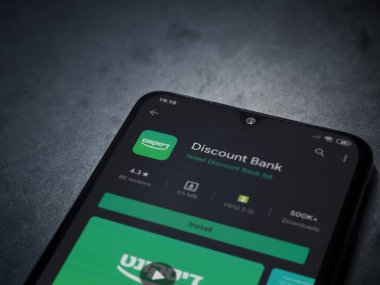 Lod, Israel - 8 Temmuz 2020: Bank Discount uygulaması oyun mağazası sayfası koyu mermer taştan arka planda siyah bir cep telefonu ekranında. Üst görünüm düzlüğü kopyalama alanı ile yatıyordu.