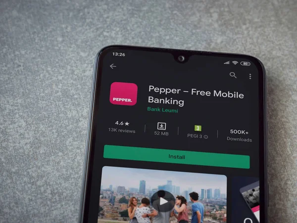 Lod, Israel - 8 Temmuz 2020: Biber uygulaması oyun mağazası sayfası seramik taş zemin üzerinde siyah bir cep telefonu görüntüsü. Üst görünüm düzlüğü kopyalama alanı ile yatıyordu.