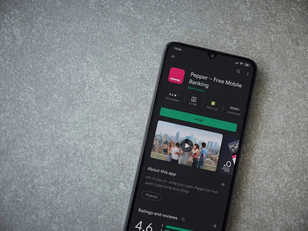 Lod, Israel - 8 Temmuz 2020: Biber uygulaması oyun mağazası sayfası seramik taş zemin üzerinde siyah bir cep telefonu görüntüsü. Üst görünüm düzlüğü kopyalama alanı ile yatıyordu.